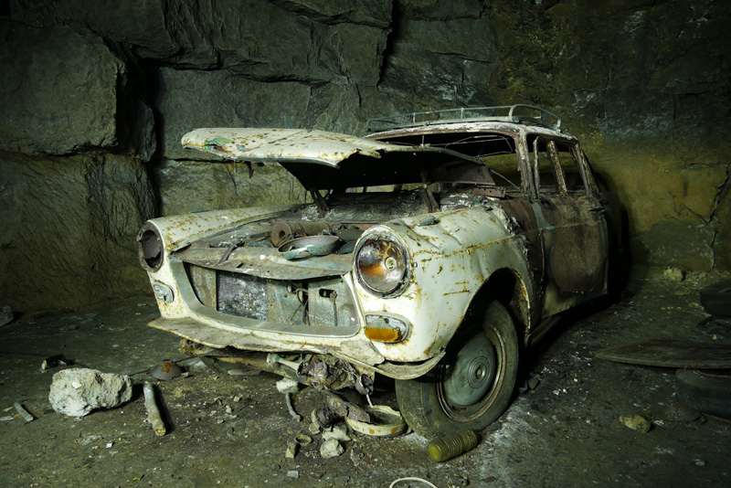 Voiture abandonnée dans une ancienne carrière de pierre